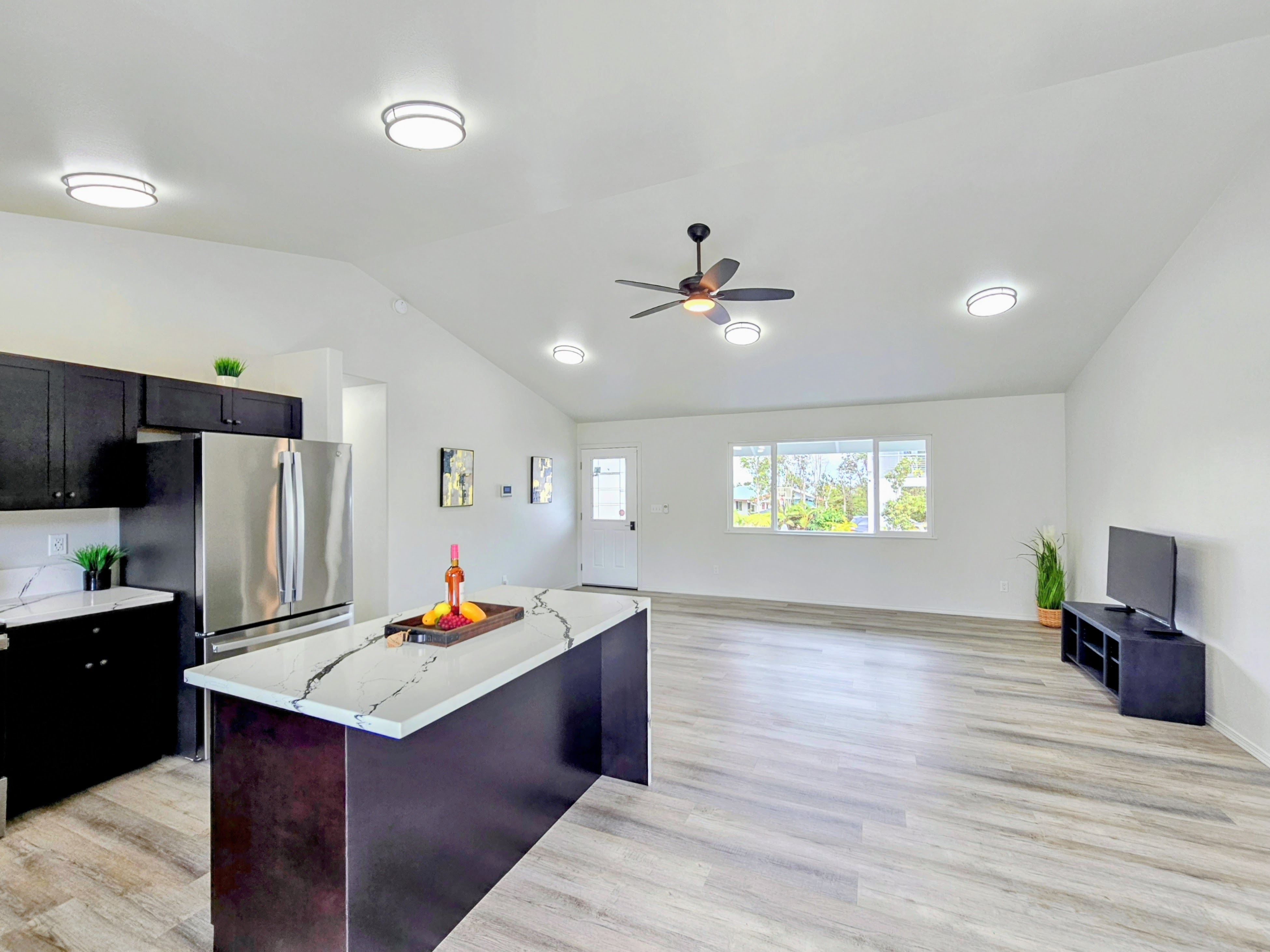 11-3385 Old Volcano Road Volcano, HI 96785 - Photo 11 of 30 a living room with stainless steel appliances kitchen island granite countertop a refrigerator and a stove