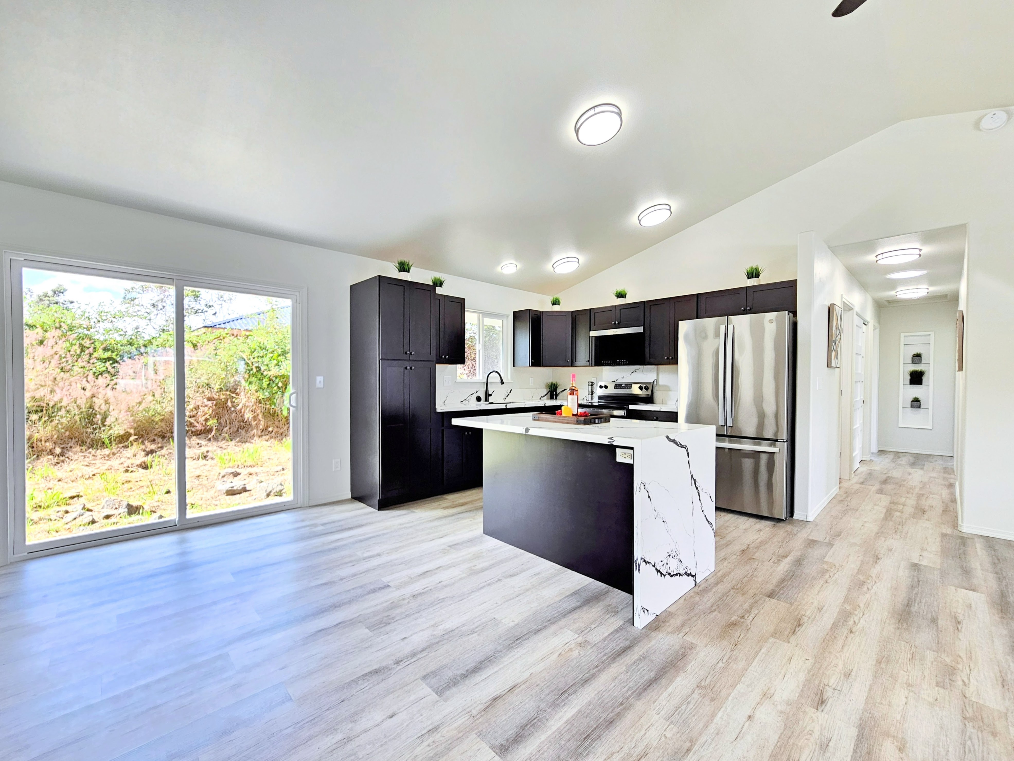 11-3385 Old Volcano Road Volcano, HI 96785 - Photo 12 of 30 a kitchen with stainless steel appliances kitchen island granite countertop a refrigerator oven a sink with dishwasher and wooden cabinets
