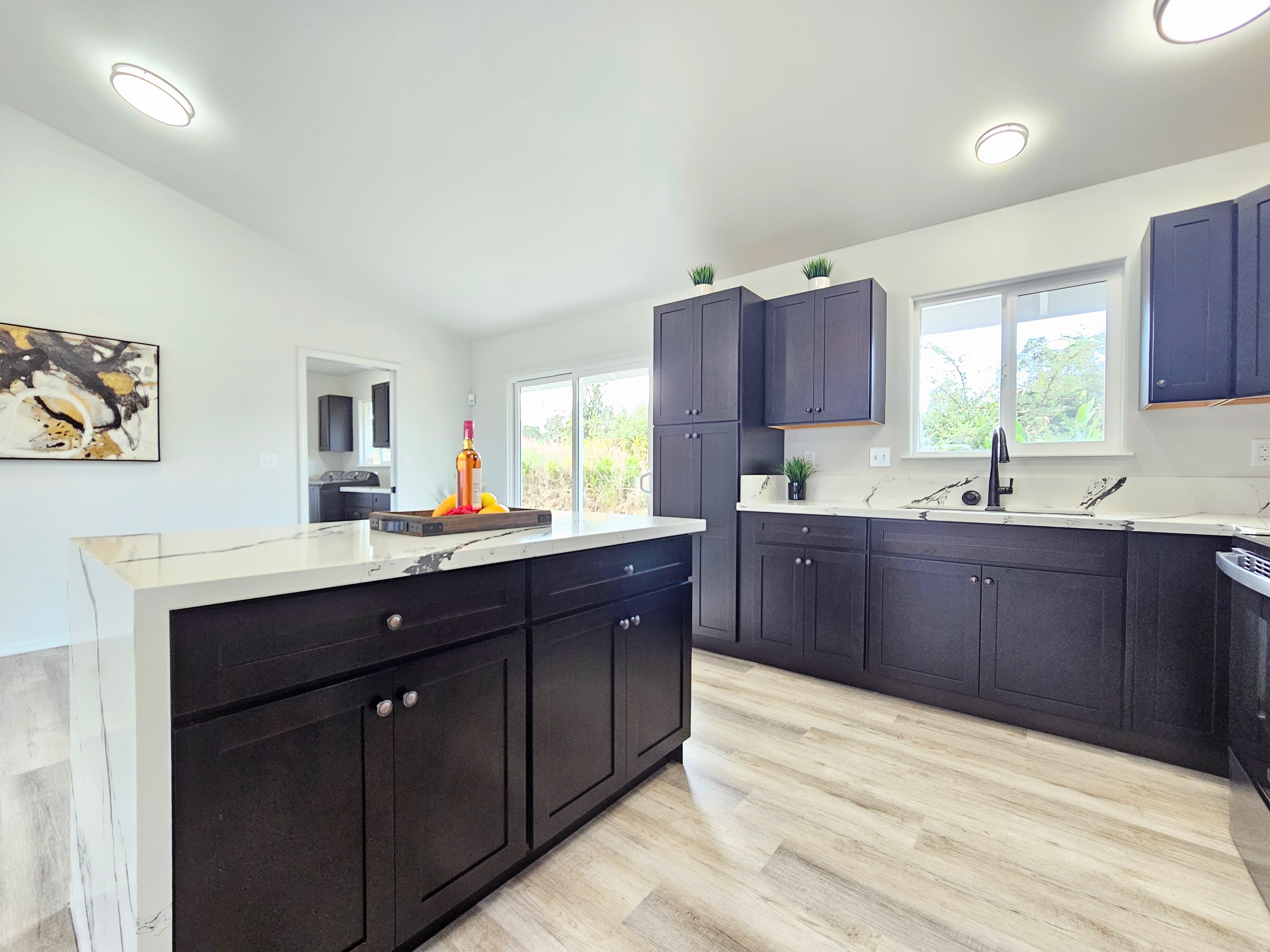 11-3385 Old Volcano Road Volcano, HI 96785 - Photo 14 of 30 a kitchen with stainless steel appliances granite countertop a sink dishwasher cabinets and wooden floor