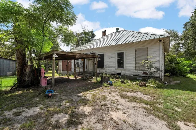 a view of a house with backyard and sitting area