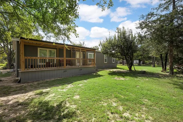 a view of house with backyard and a tree