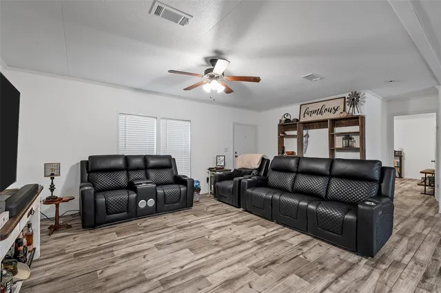 a living room with furniture and a ceiling fan