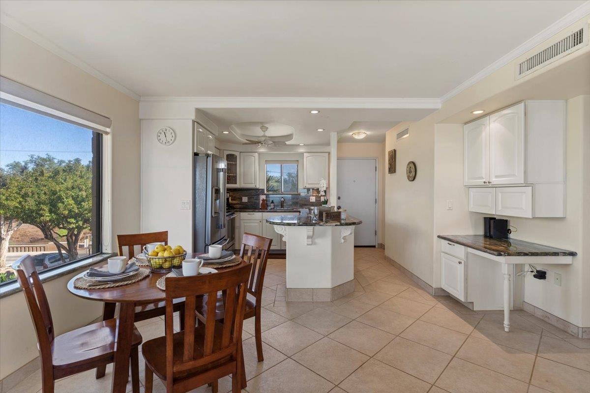 36 South Kihei Road, Unit 301 Kihei, HI 96753 - Photo 11 of 30 a kitchen with a dining table chairs and white cabinets