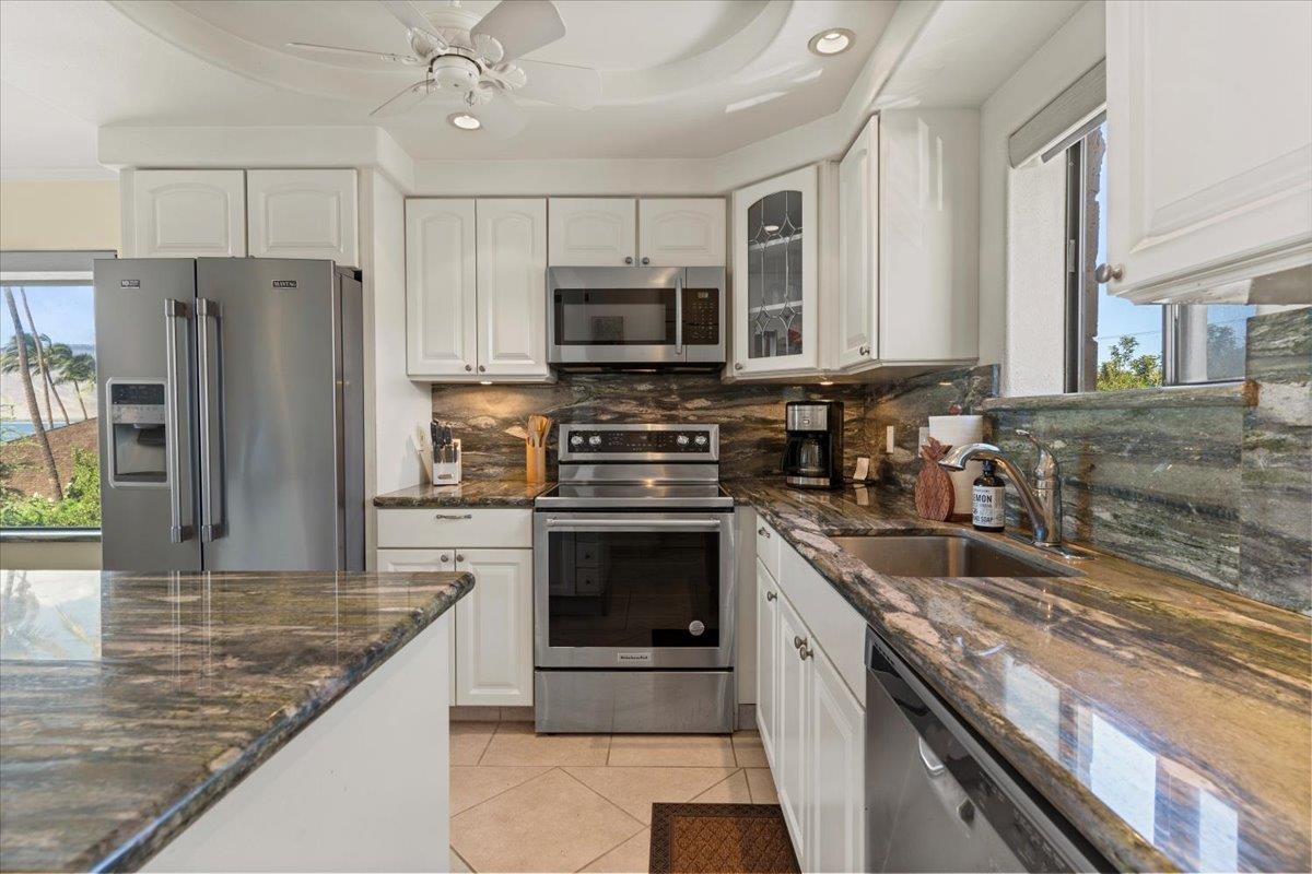 36 South Kihei Road, Unit 301 Kihei, HI 96753 - Photo 14 of 30 a kitchen with stainless steel appliances granite countertop a stove top oven a sink and a refrigerator