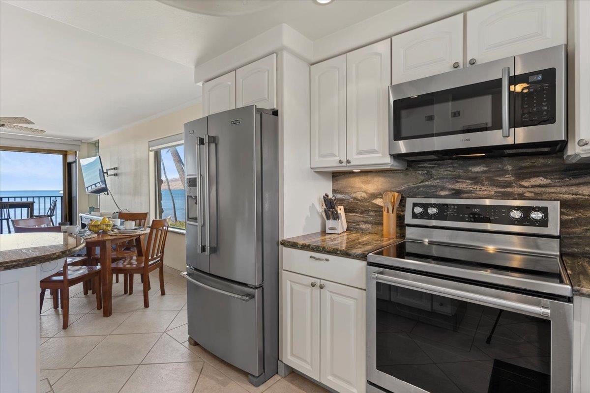36 South Kihei Road, Unit 301 Kihei, HI 96753 - Photo 15 of 30 a kitchen with stainless steel appliances granite countertop a refrigerator stove and microwave