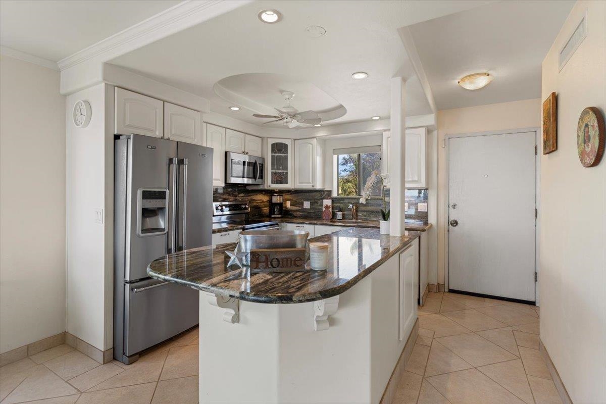 36 South Kihei Road, Unit 301 Kihei, HI 96753 - Photo 18 of 30 a kitchen with stainless steel appliances granite countertop a refrigerator a sink and a stove