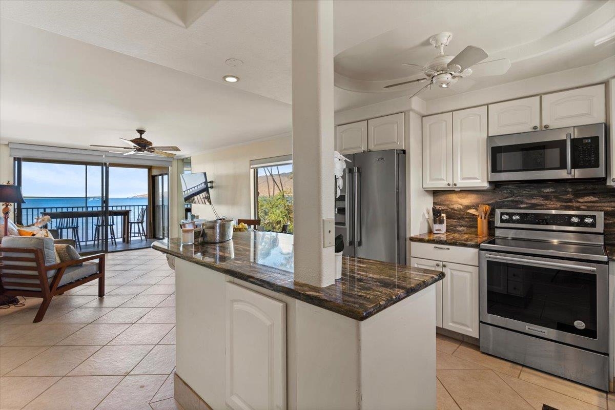 36 South Kihei Road, Unit 301 Kihei, HI 96753 - Photo 19 of 30 a kitchen with stainless steel appliances granite countertop a stove refrigerator and microwave
