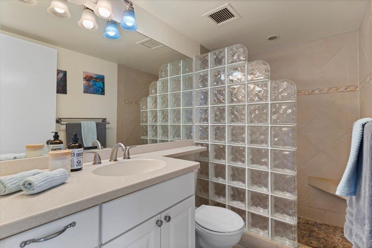 36 South Kihei Road, Unit 301 Kihei, HI 96753 - Photo 23 of 30 a bathroom with a double vanity sink a toilet and a mirror