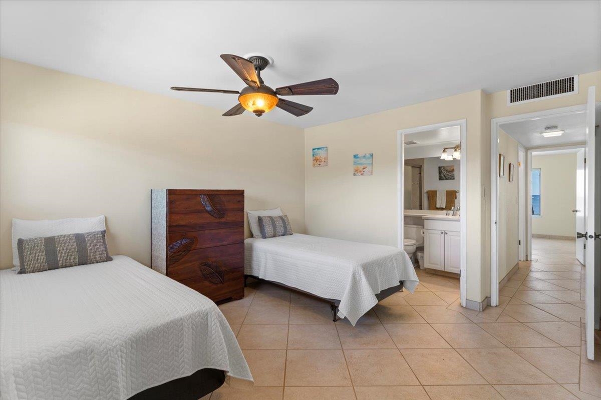 36 South Kihei Road, Unit 301 Kihei, HI 96753 - Photo 25 of 30 a bedroom with a bed and a chandelier