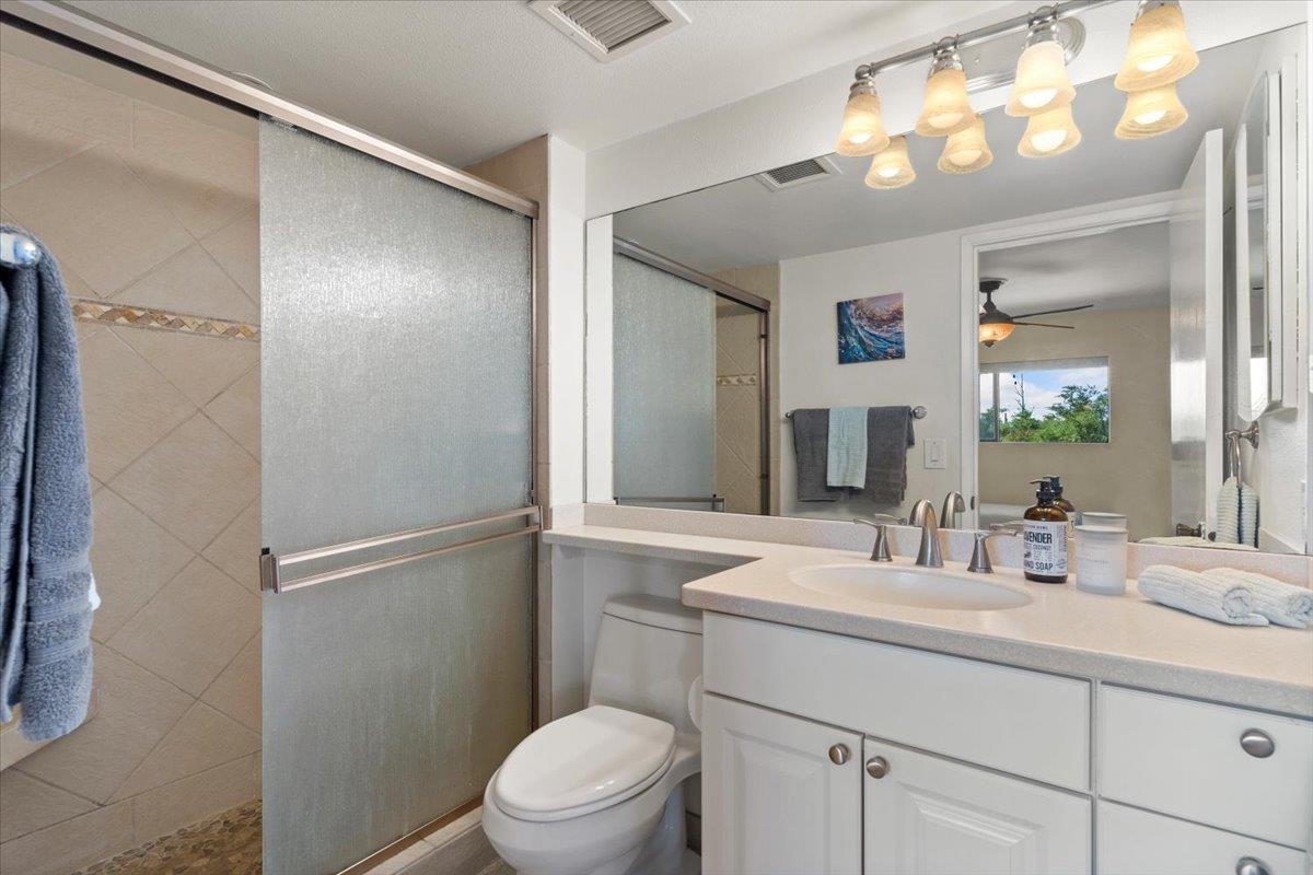 36 South Kihei Road, Unit 301 Kihei, HI 96753 - Photo 27 of 30 a bathroom with a toilet a sink and a mirror
