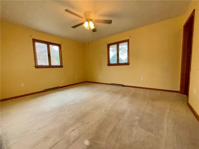 an empty room with a ceiling fan and a window