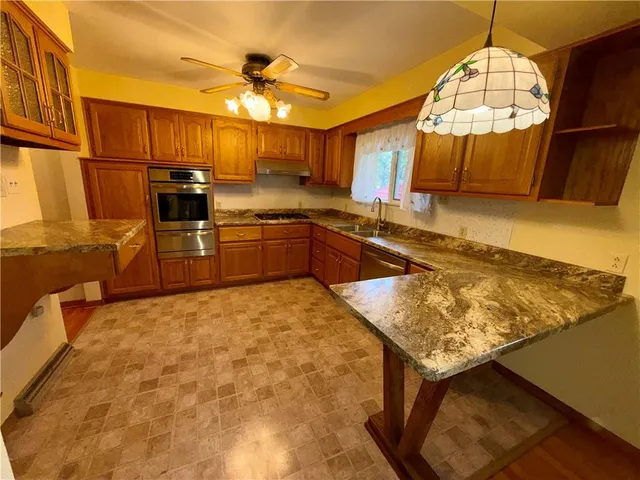 a kitchen with stainless steel appliances granite countertop a stove a sink and a microwave