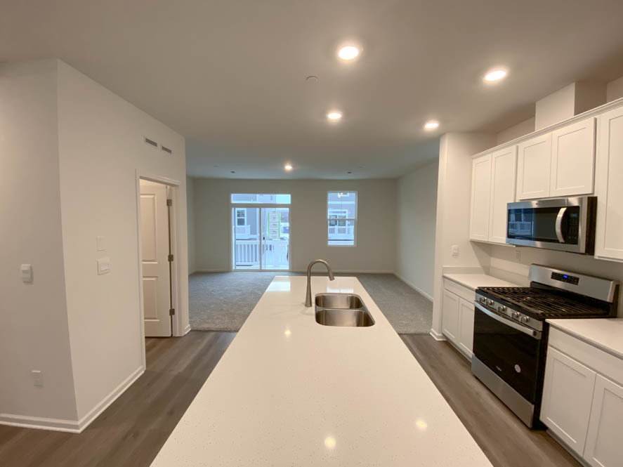 577 Yosemite Way Mundelein, IL 60060 - Photo 8 of 42 a kitchen with stainless steel appliances a stove a sink a refrigerator white cabinets and a wooden floor