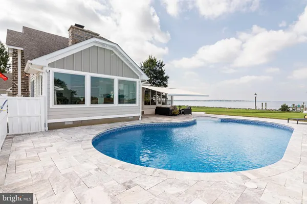 a view of a house with swimming pool and sitting area