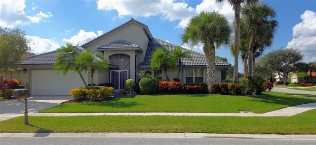 a front view of a house with a garden and plants