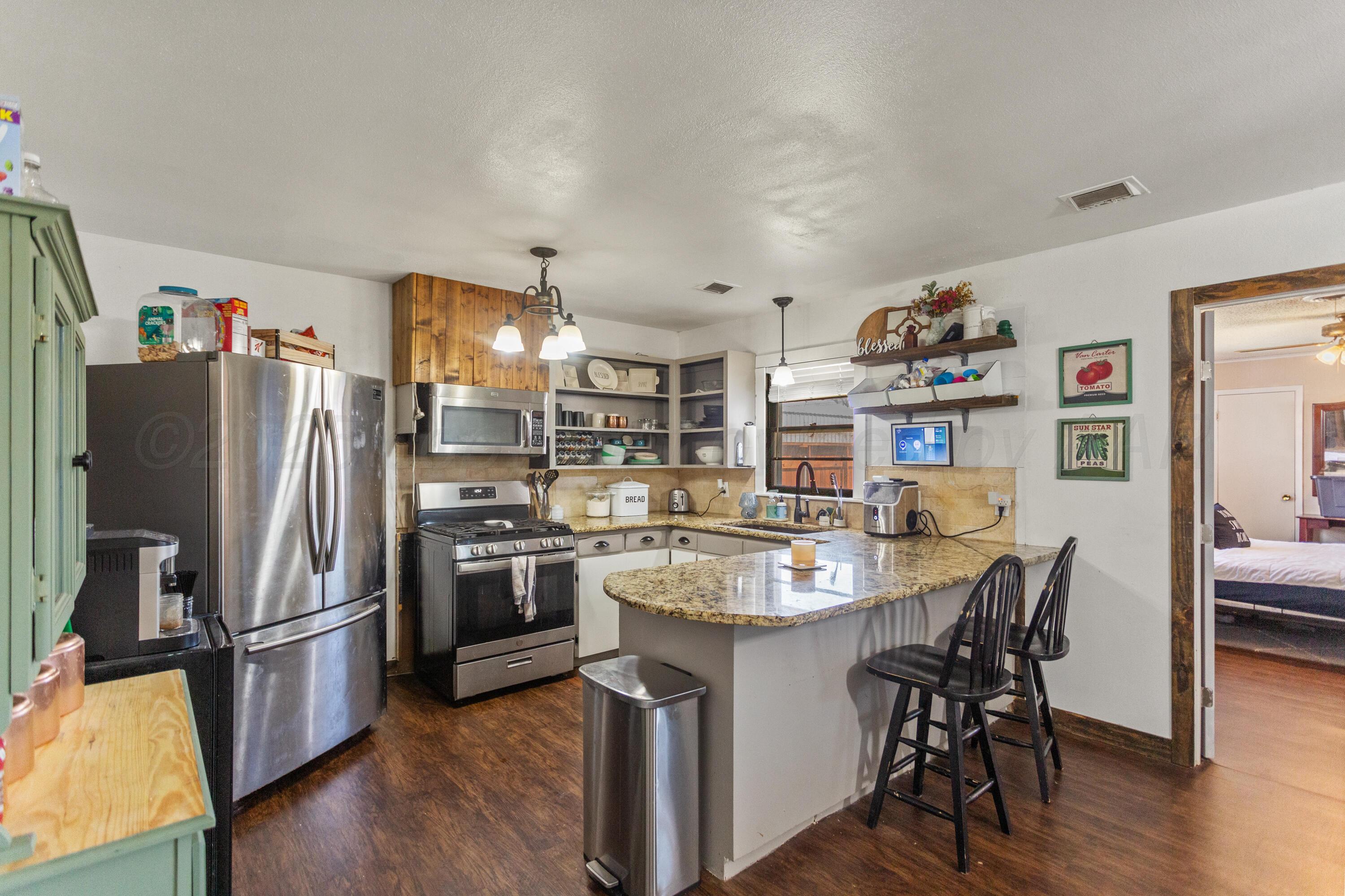 920 South Madden Street Shamrock, TX 79079 - Photo 11 of 39 a kitchen with refrigerator and wooden floor