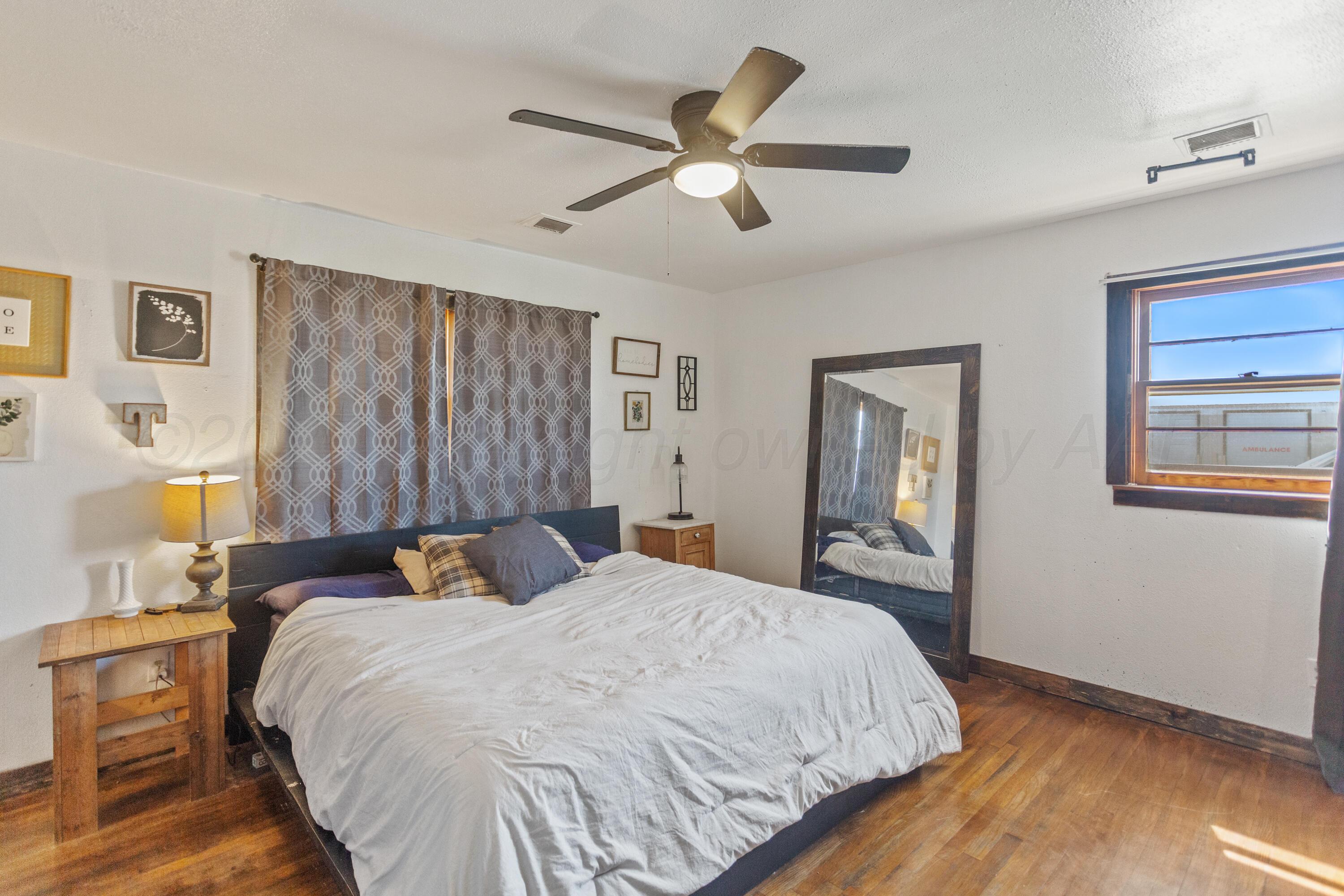 920 South Madden Street Shamrock, TX 79079 - Photo 15 of 39 a bed room with a bed and a chandelier