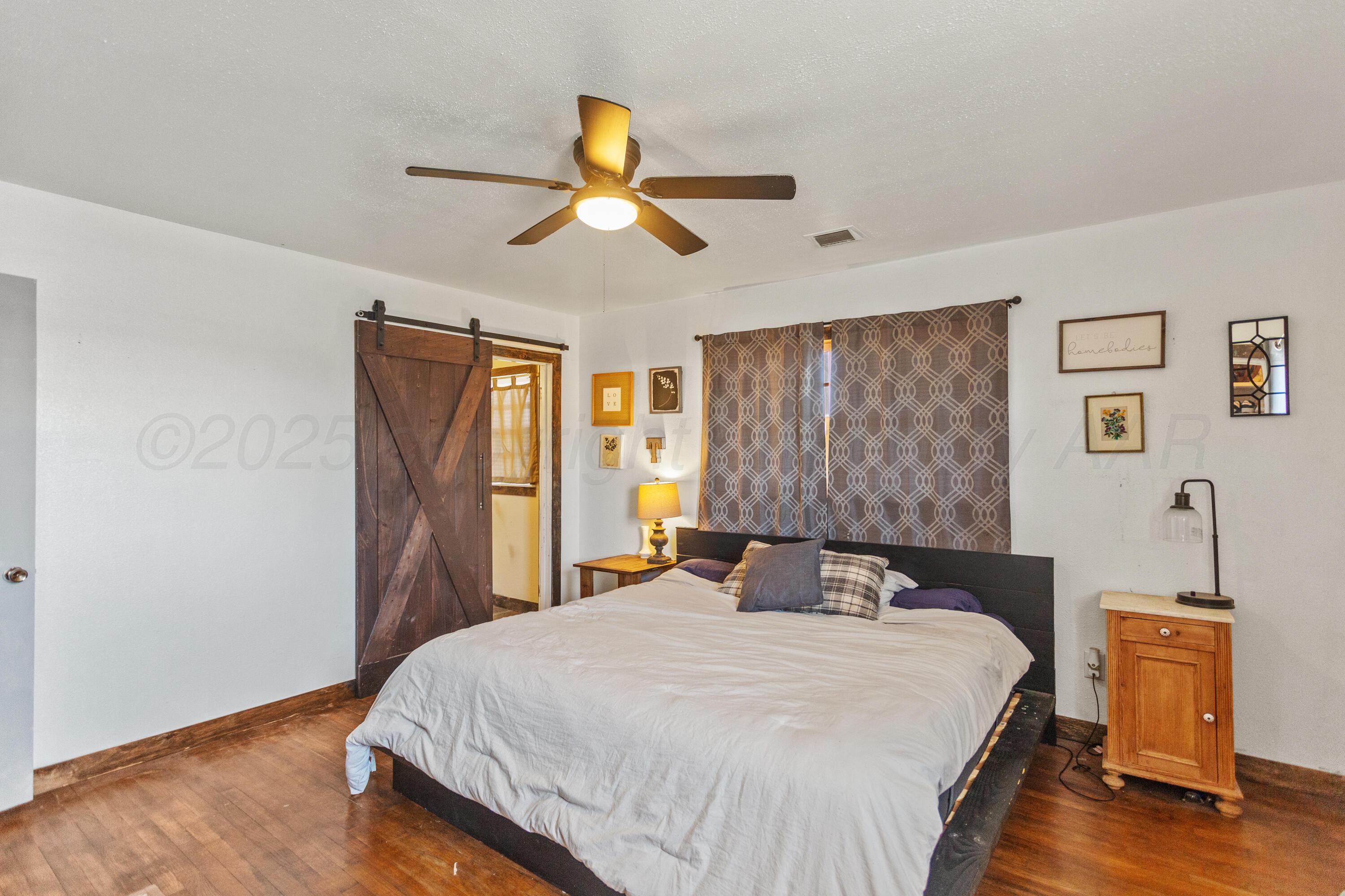 920 South Madden Street Shamrock, TX 79079 - Photo 17 of 39 a bedroom with a bed and wooden floor