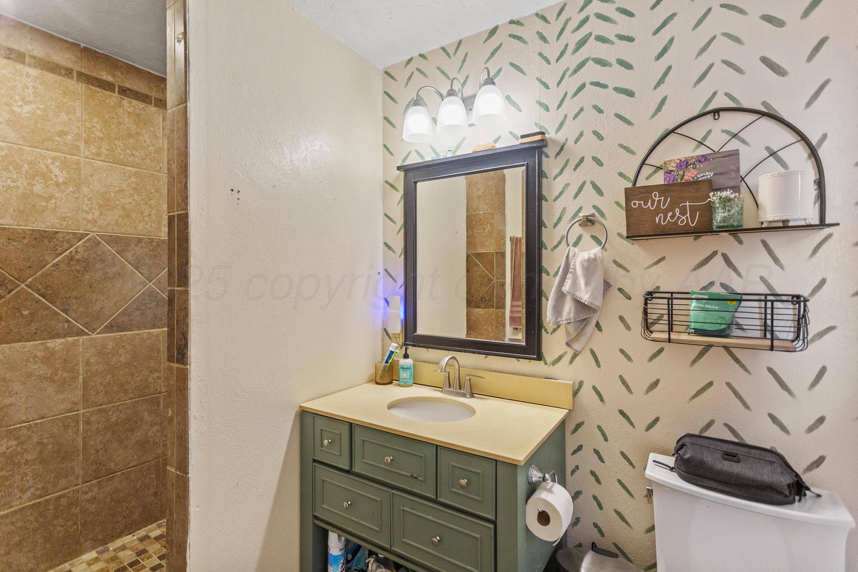 920 South Madden Street Shamrock, TX 79079 - Photo 18 of 39 a bathroom with a sink and a mirror