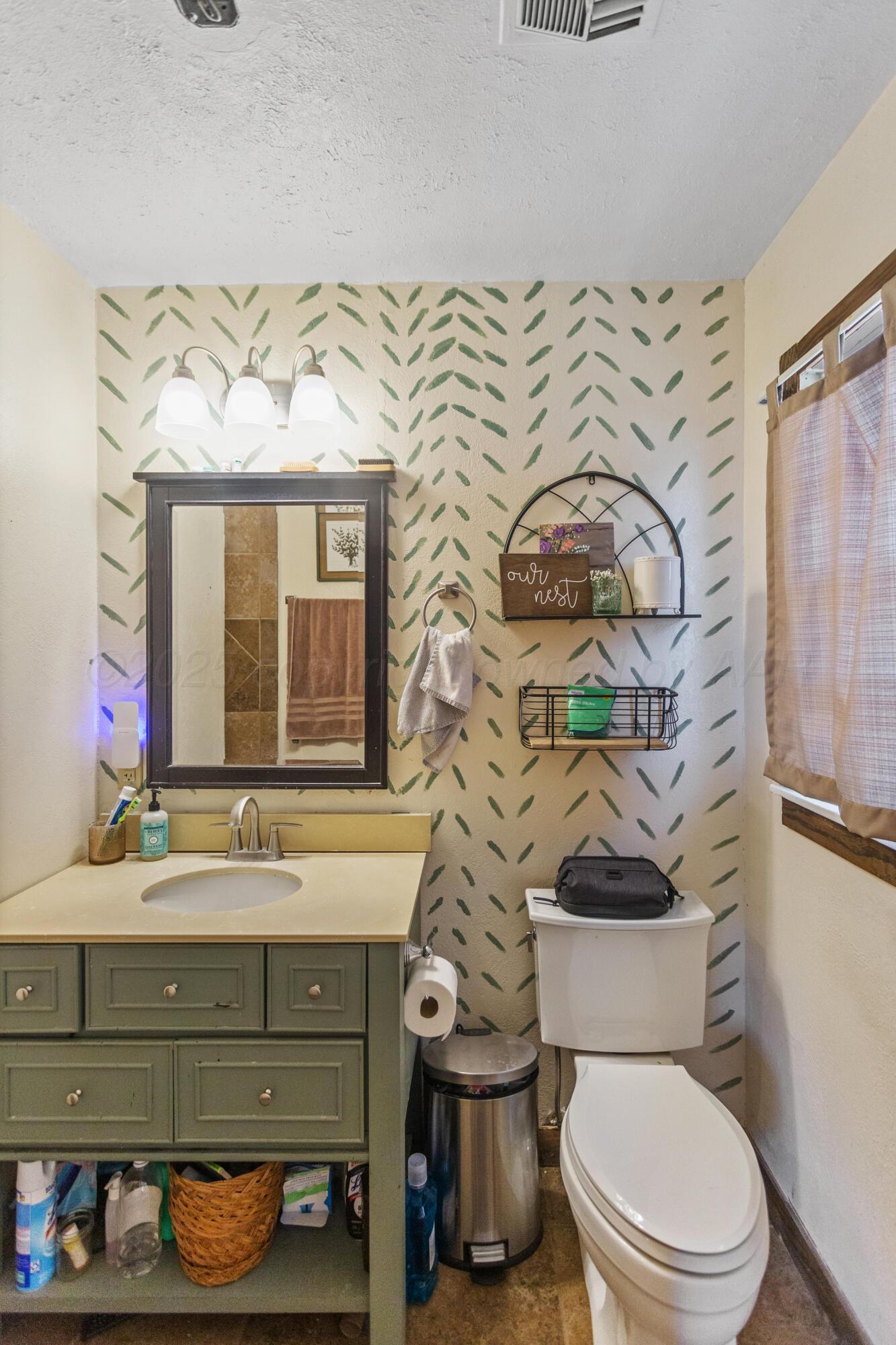920 South Madden Street Shamrock, TX 79079 - Photo 19 of 39 a bathroom with a toilet sink and mirror