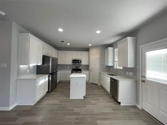 a kitchen with stainless steel appliances granite countertop a refrigerator stove microwave and sink