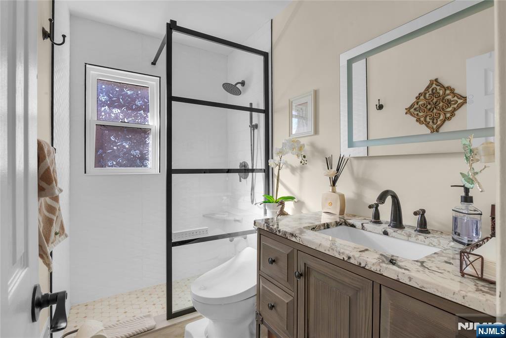 170 Tenafly Road Englewood, NJ 07631 - Photo 14 of 40 a bathroom with a granite countertop sink mirror vanity and toilet