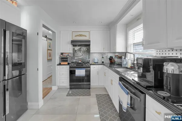 a kitchen with stainless steel appliances granite countertop a refrigerator and a stove