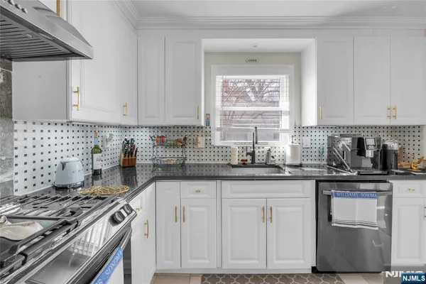 a kitchen with stainless steel appliances granite countertop a refrigerator a stove a sink and a refrigerator