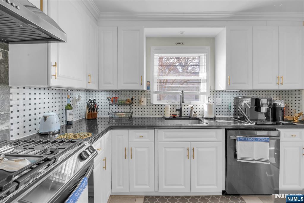 170 Tenafly Road Englewood, NJ 07631 - Photo 10 of 40 a kitchen with granite countertop a sink stove and cabinets