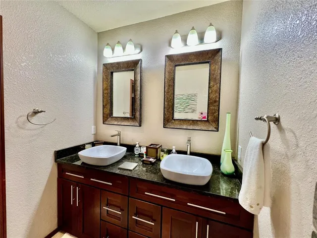 a bathroom with a granite countertop sink and a mirror