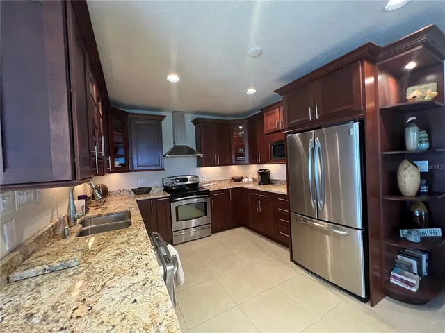 a kitchen with granite countertop a refrigerator and a sink