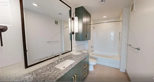 a bathroom with a granite countertop sink a mirror and a bathtub
