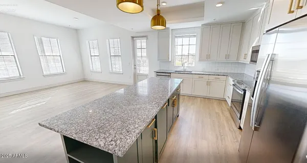 a kitchen with stainless steel appliances granite countertop a sink window and refrigerator