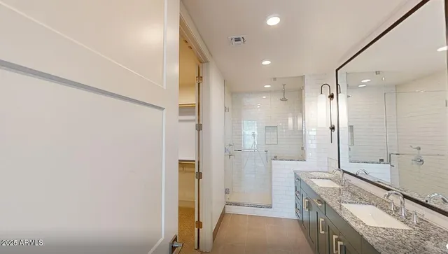 a bathroom with a granite countertop sink a mirror and a shower