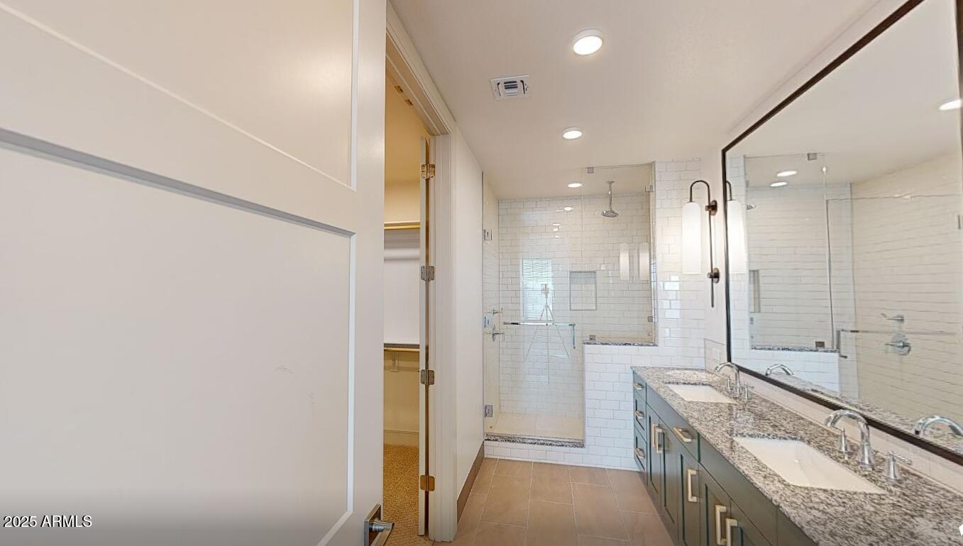 98 South River Drive, Unit C1 Tempe, AZ 85288 - Photo 6 of 20 a bathroom with a granite countertop sink a mirror and a shower