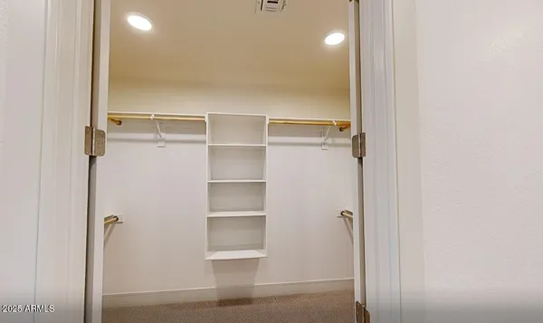 a view of walk in closet with empty racks