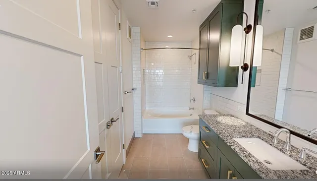 a bathroom with a granite countertop sink a toilet a large mirror and shower
