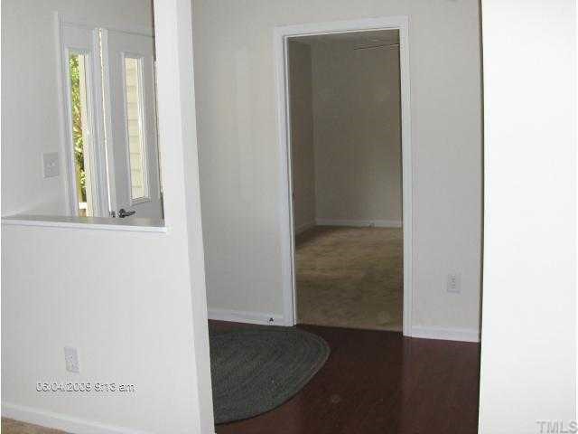 2339 Lucy Garrett Road Roxboro, NC 27574 - Photo 3 of 9 an empty room with wooden floor mirror and windows