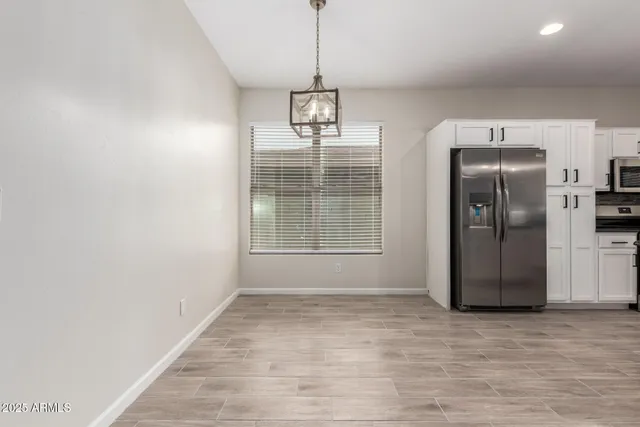 a view of a refrigerator in kitchen and wooden floor