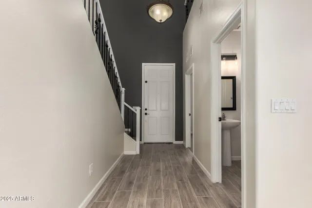 a view of a hallway with wooden floor and staircase