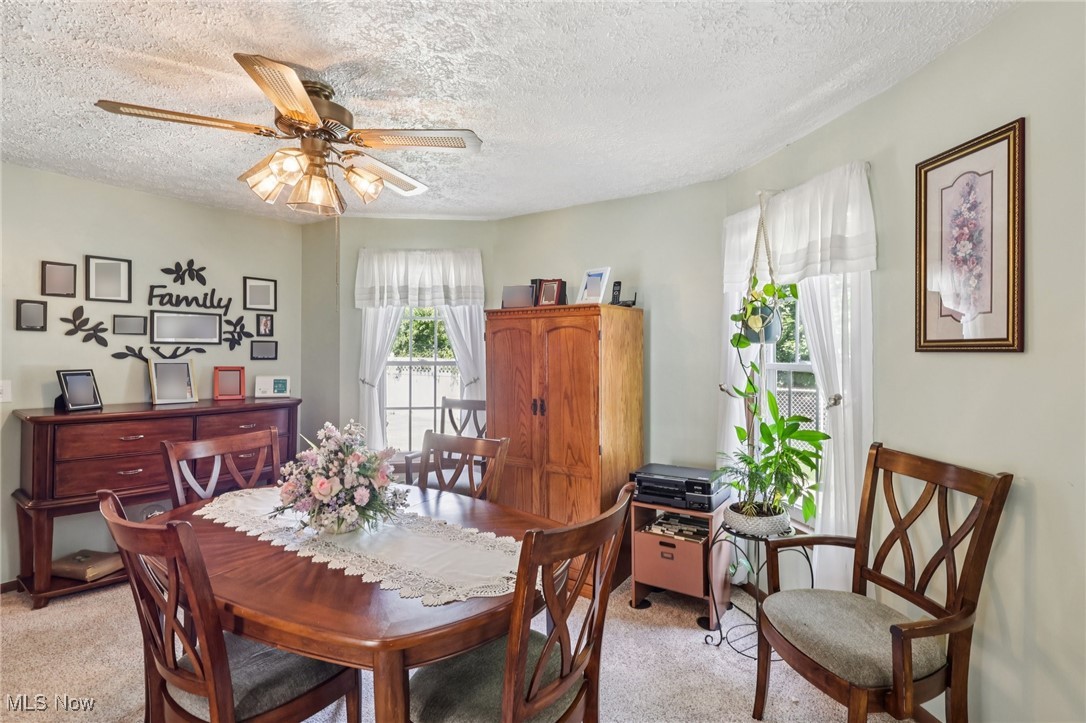 10818 Dixon Road Cleveland, OH 44111 - Photo 10 of 44 Dining space featuring a textured ceiling, light carpet, and a ceiling fan