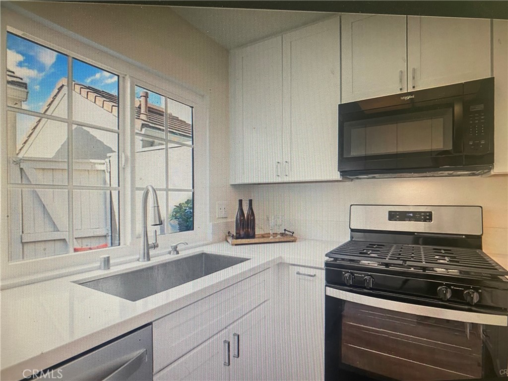 5 Wellesley, Unit 12 Irvine, CA 92612 - Photo 1 of 4 a kitchen with stainless steel appliances a stove a microwave and sink