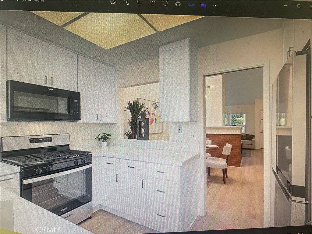 5 Wellesley, Unit 12 Irvine, CA 92612 - Photo 2 of 4 a kitchen with a sink and a stove top oven