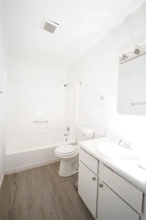 a bathroom with a double vanity sink mirror and toilet