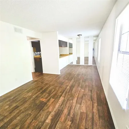 a view of a room with wooden floor and windows