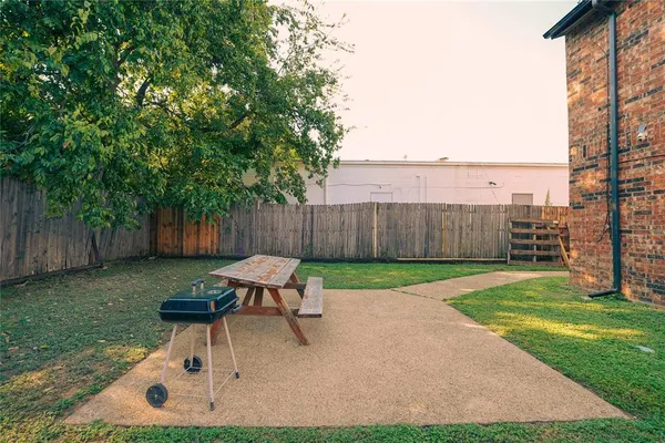 a view of a backyard with table and chairs and wooden fence