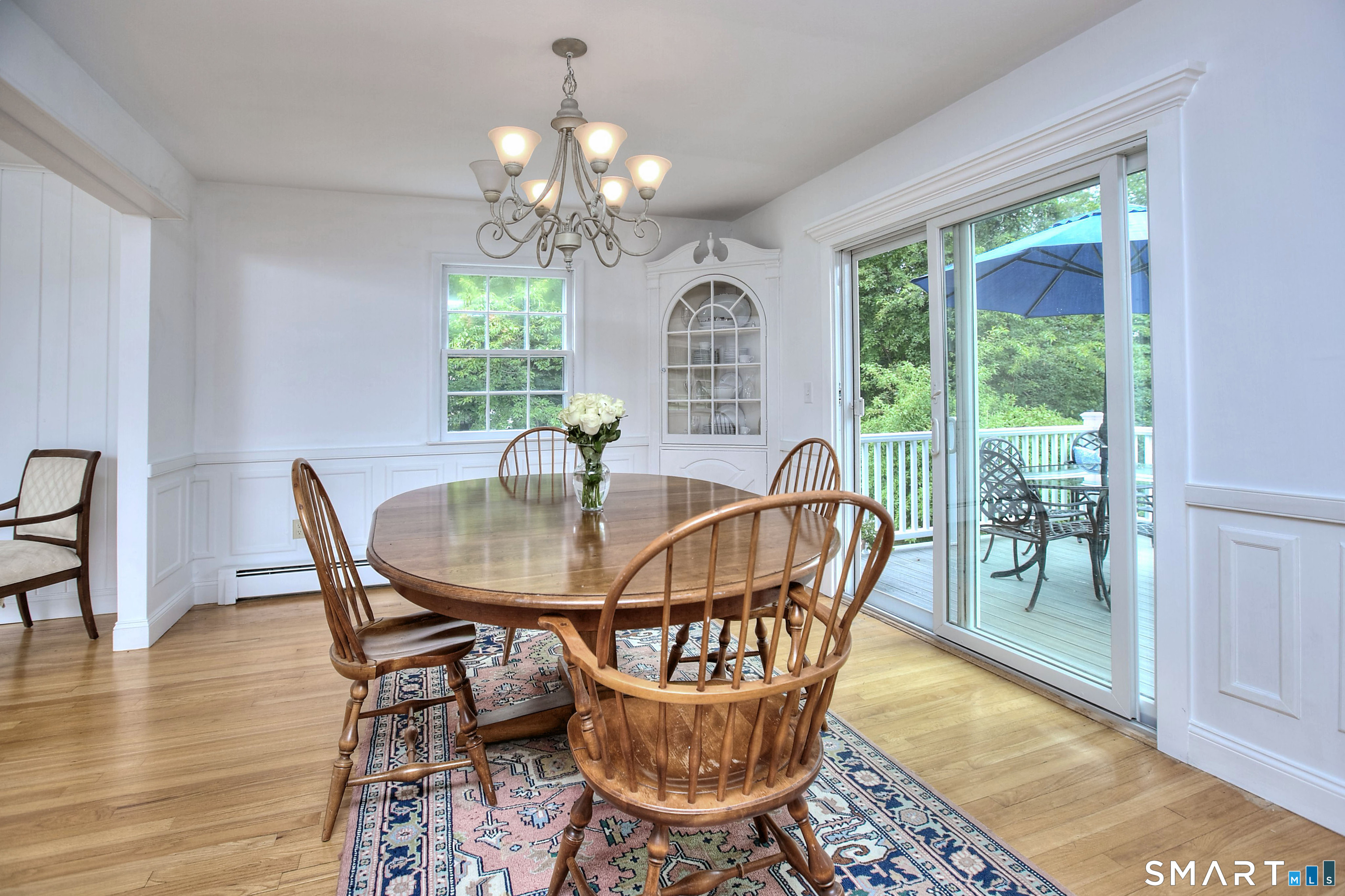324 Ridge Road Orange, CT 06477 - Photo 9 of 38 a dining room with furniture a rug a potted plant and a chandelier