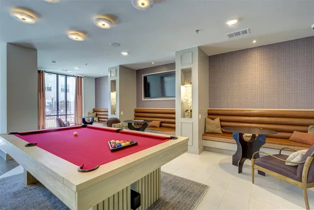 a room with pool table and windows