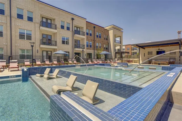 a view of building with swimming pool and patio