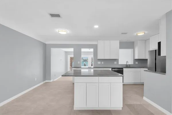 a kitchen with white cabinets and refrigerator